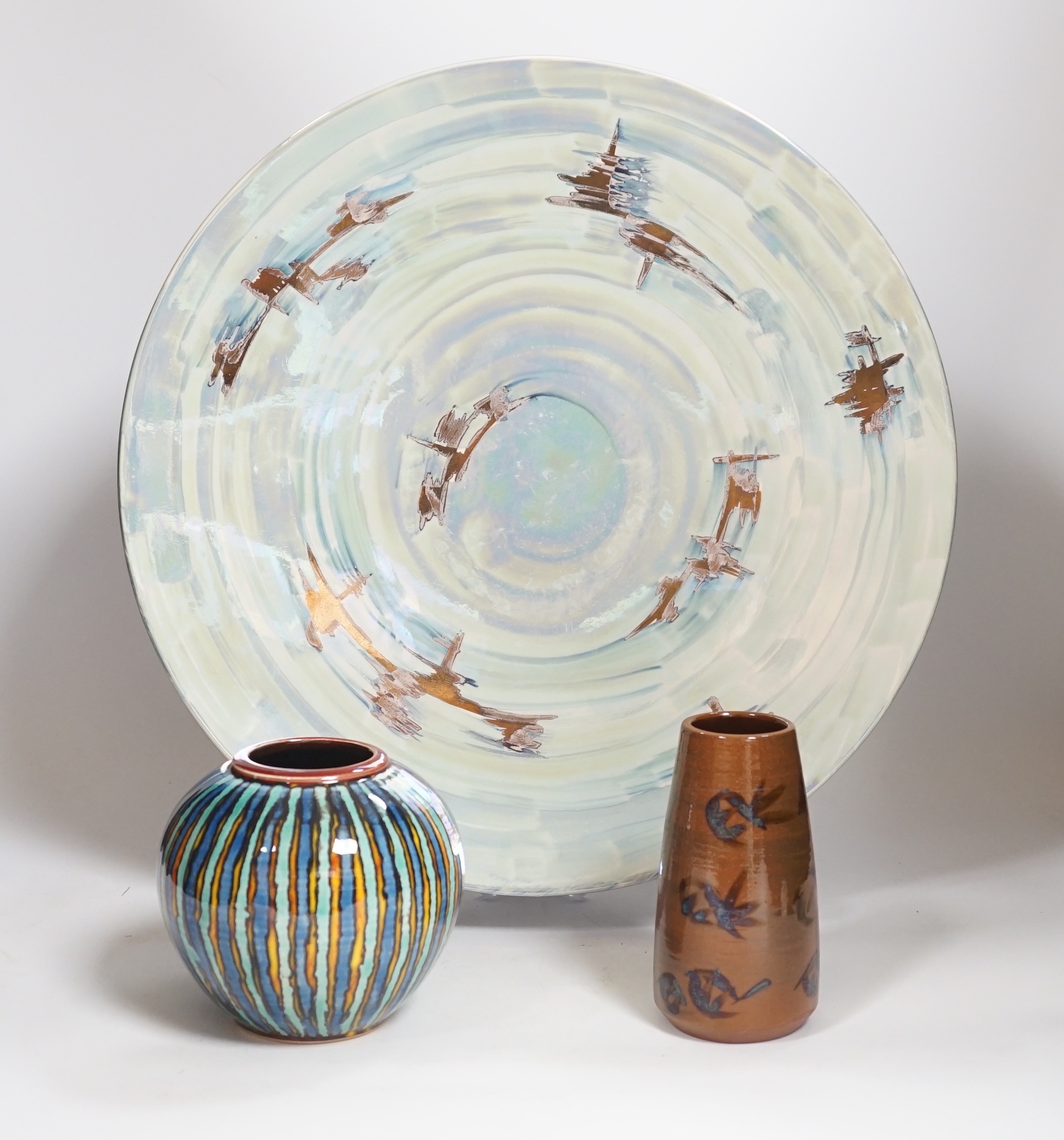 A Poole pottery lustre charger, initialled ‘MS’, 40cm and two vases with abstract designs, largest 40cm in diameter